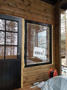 Musta mökkiovi ja mökki-ikkuna